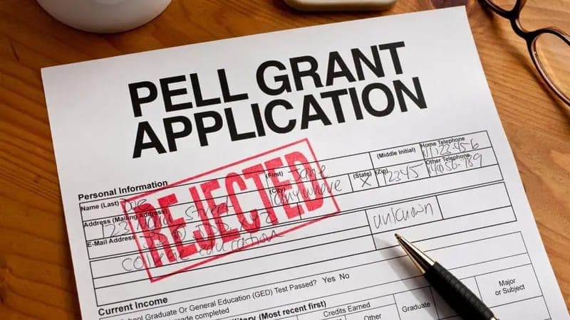 Grant application stamped rejected next to a pen