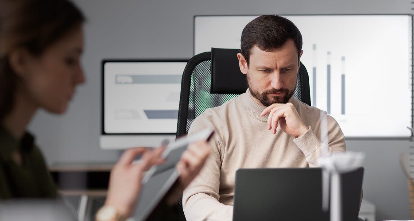 Founder weighing grant readiness at his desk